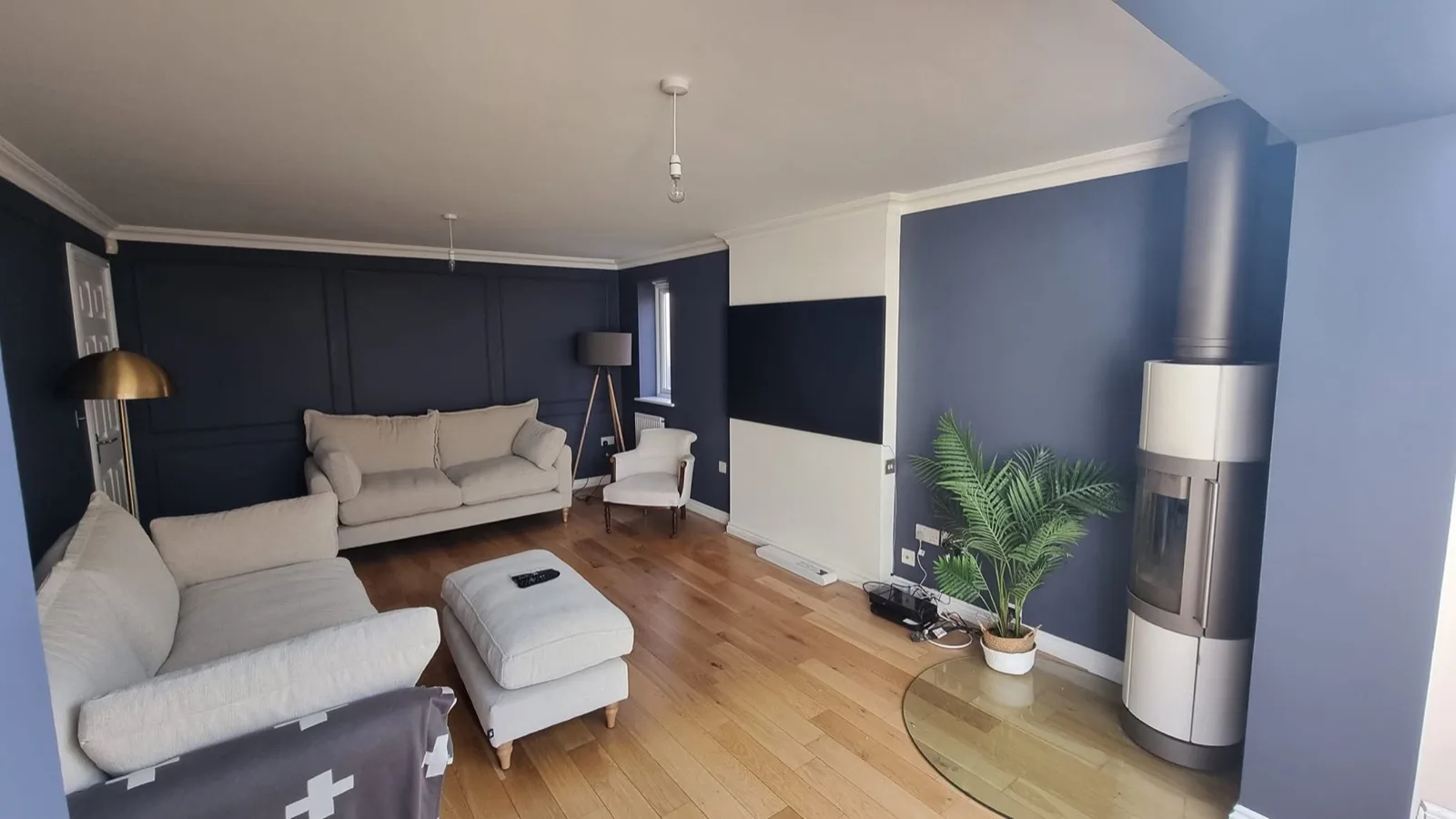 Living room after: panelled and two-tone walls finished in deep navy blue