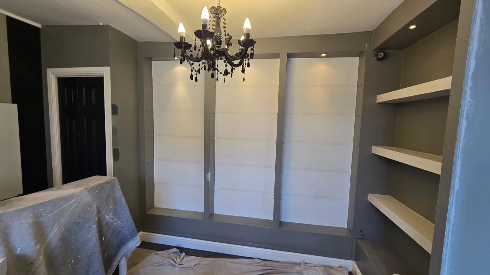 Salon fit-out before: bare grey walls and unfinished fitted alcove shelving